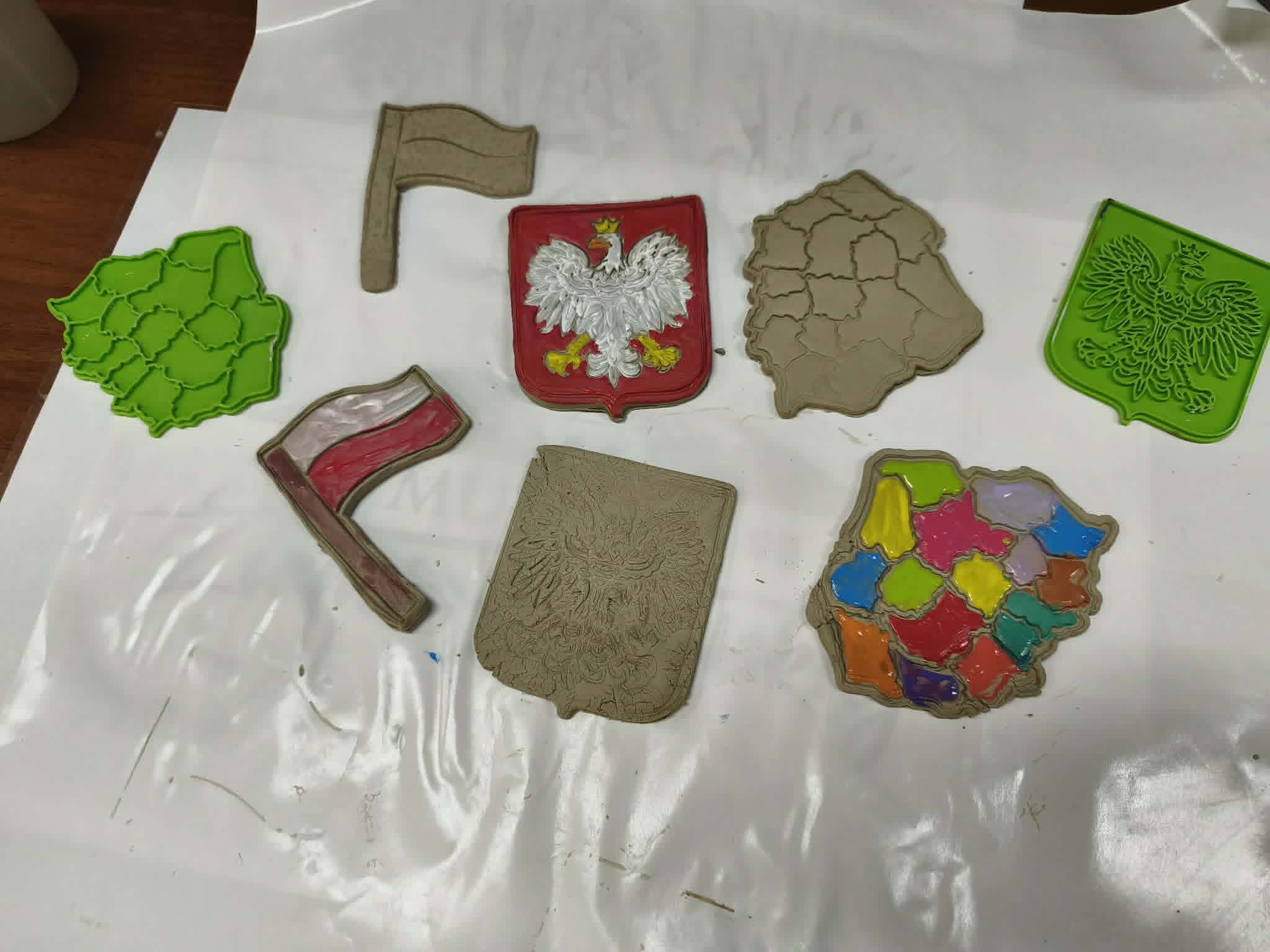 Wyroby z&nbsp;gliny i&nbsp;plasteliny: godło Polski z&nbsp;orłem białym, flagi oraz kontury mapy Polski z&nbsp;podziałem na województwa.
